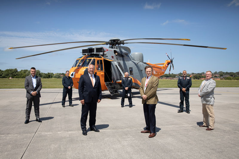 Representatives of Leonardo Helicopters and HeliOps stand in front of the Westland Sea King XV666 helicopter at Yeovil, on its 50th anniversary