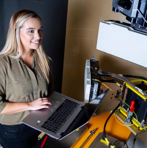 Young female engineer testing a radar with software on a laptop