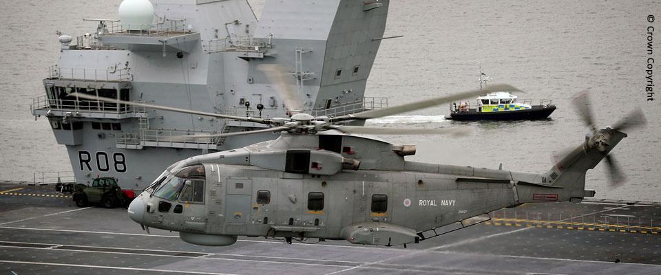 AW101 helicopter hovers over HMS Queen Elizabeth