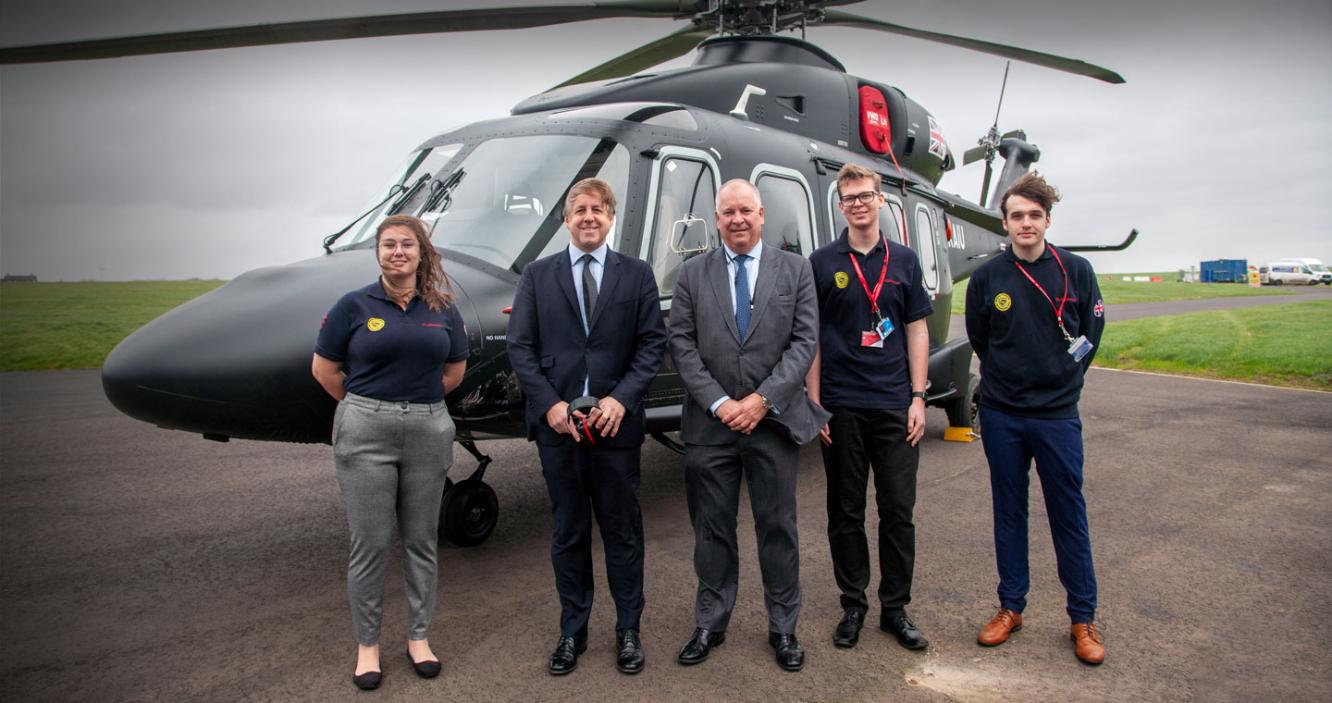Nick Whitney, Marcus Fysh MP and Leonardo apprentices in front of the AW149 helicopter in Yeovil