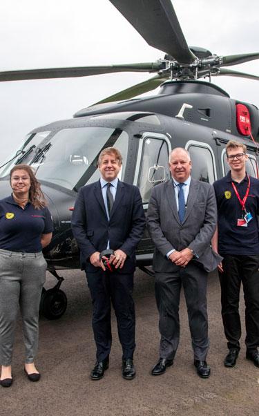 Nick Whitney, Marcus Fysh MP and Leonardo apprentices in front of the AW149 helicopter in Yeovil
