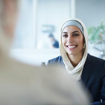 Woman in hijab smiling during a meeting