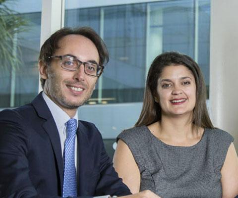 Man and woman in meeting room smile, facing camera