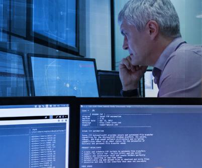 Cyber security expert looking at two screens