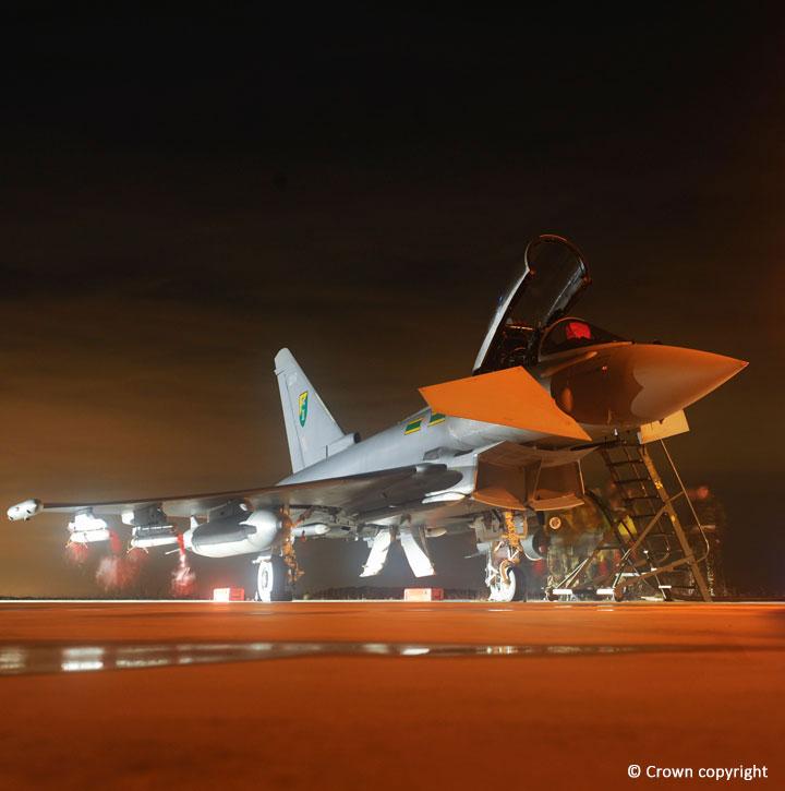 Typhoon shot at night, lit up and being prepared on the runway