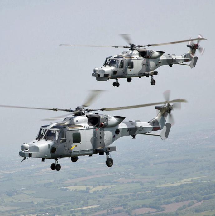 Two AW159 Wildcat helicopters in flight over UK countryside