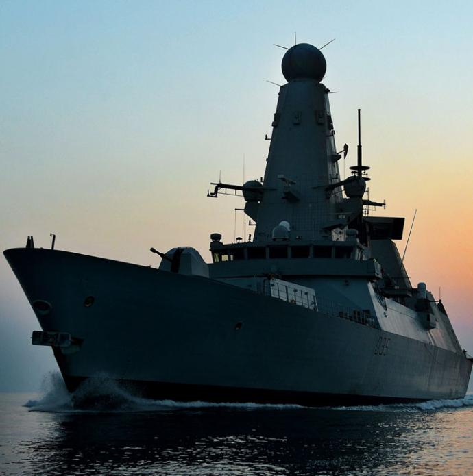 Photo of naval frigate shot as the sun is going down behind it