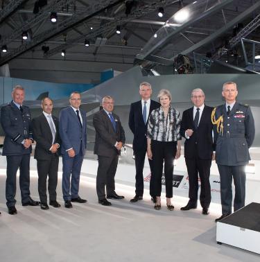 Prime Minister Theresa May, Royal Air Force Chief Air Staff and CEOs of Team Tempest partners standing in front of the concept aircraft